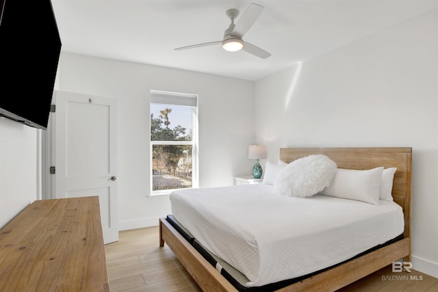 bedroom with ceiling fan, light wood-type flooring, and baseboards