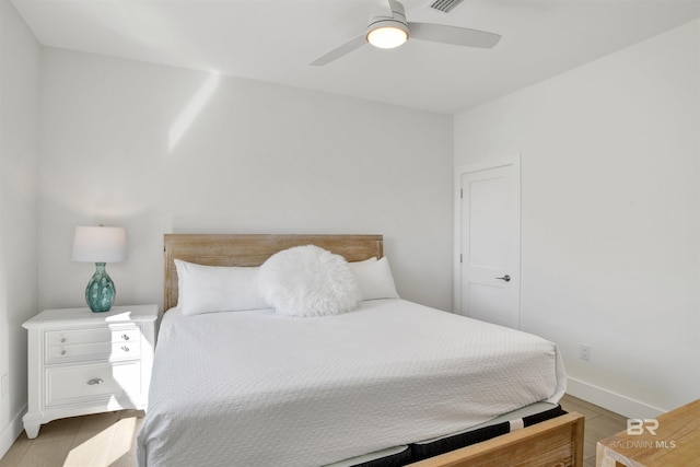 bedroom featuring light wood finished floors, baseboards, and a ceiling fan