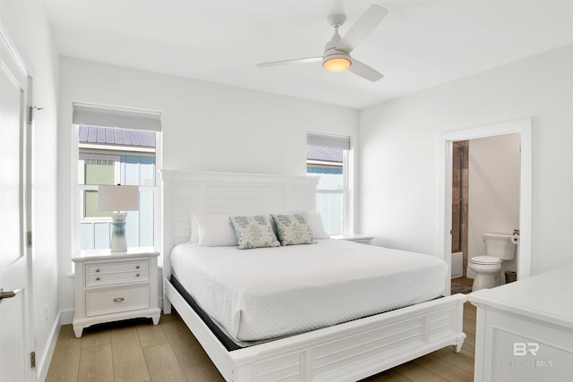 bedroom featuring ceiling fan, connected bathroom, and light wood-style flooring