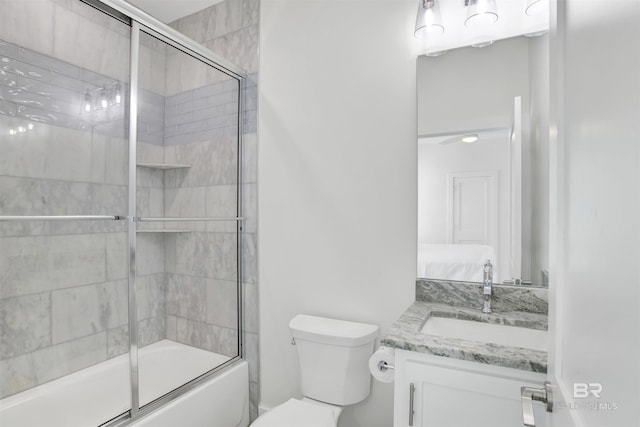 bathroom with toilet, bath / shower combo with glass door, and vanity