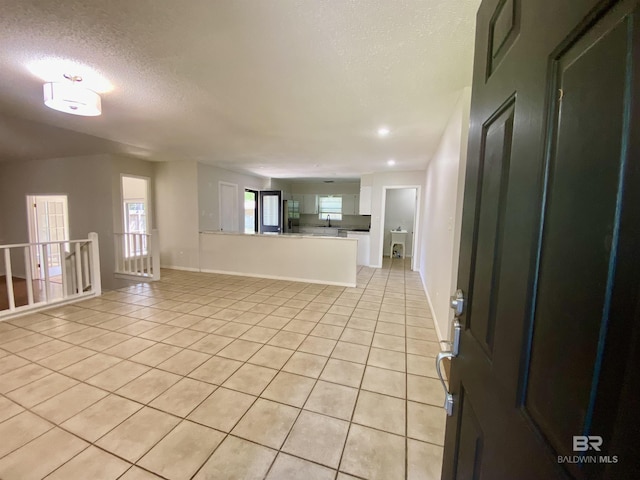 interior space featuring light tile patterned floors, plenty of natural light, and a textured ceiling