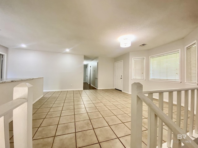 empty room with light tile patterned floors, visible vents, baseboards, and recessed lighting