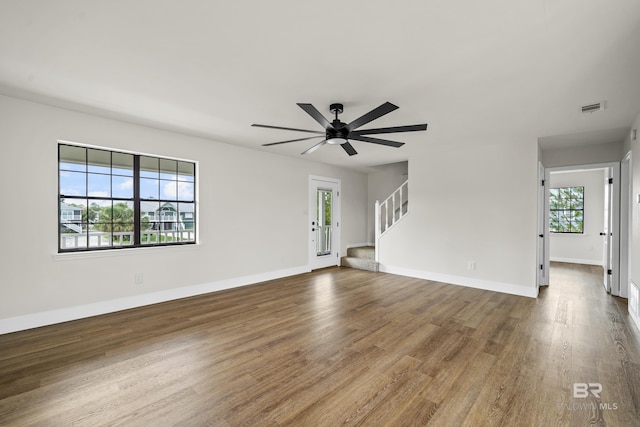 26498 Carondelette Dr, Orange Beach, AL 36561 - unfurnished living room featuring wood finished floors, stairway, baseboards, and a ceiling fan