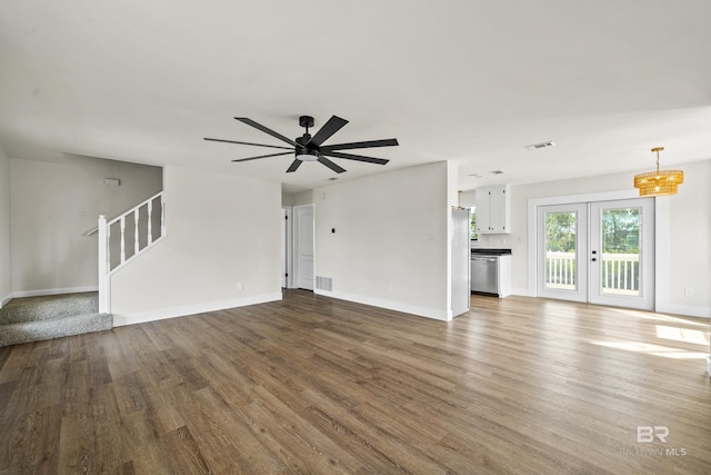 26498 Carondelette Dr, Orange Beach, AL 36561 - unfurnished living room featuring wood finished floors, baseboards, and stairway