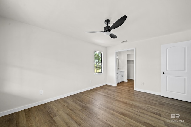 26498 Carondelette Dr, Orange Beach, AL 36561 - unfurnished bedroom with wood finished floors, baseboards, a spacious closet, and ceiling fan