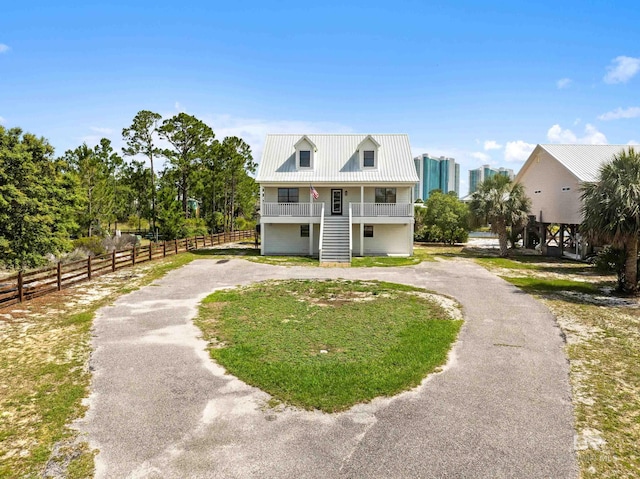 26498 Carondelette Dr, Orange Beach, AL 36561 - coastal inspired home with stairway, curved driveway, fence, and covered porch