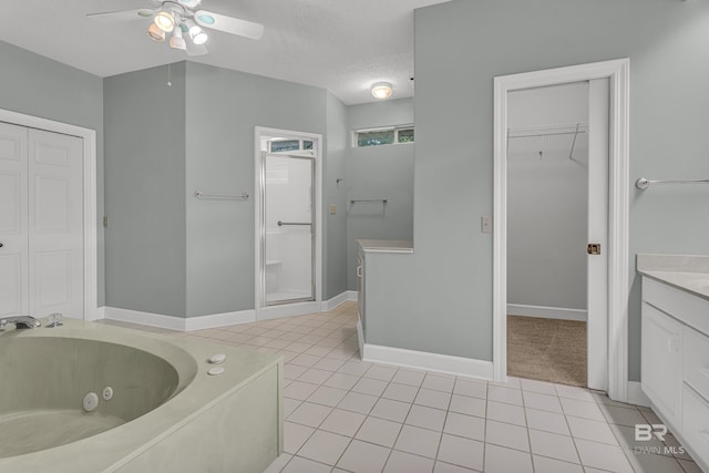 bathroom featuring vanity, a jetted tub, ceiling fan, a textured ceiling, and tile patterned floors