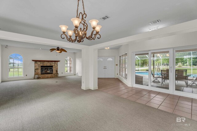 unfurnished living room with visible vents, carpet, a glass covered fireplace, and tile patterned floors