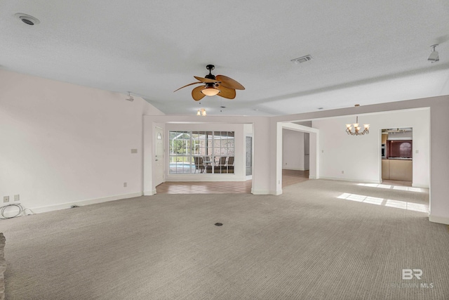 unfurnished living room featuring ceiling fan with notable chandelier, baseboards, light colored carpet, and visible vents