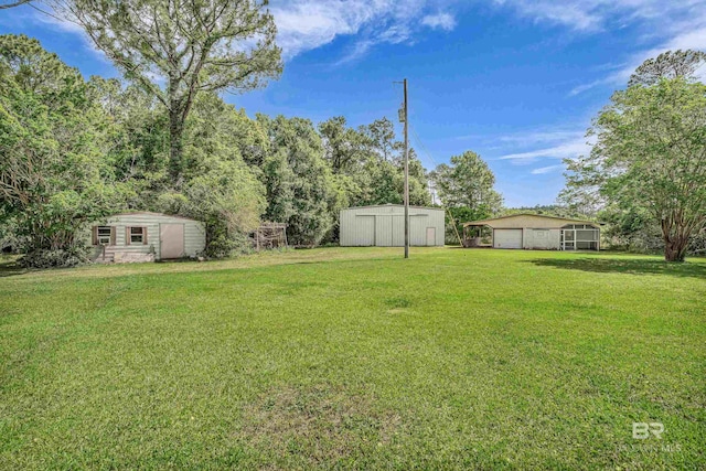 view of yard featuring an outdoor structure, a storage unit, and a detached garage