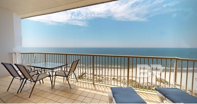 balcony featuring a water view and a beach view