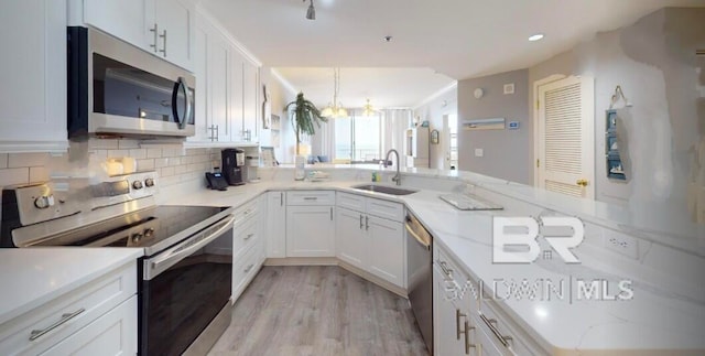 kitchen featuring kitchen peninsula, white cabinetry, sink, and appliances with stainless steel finishes