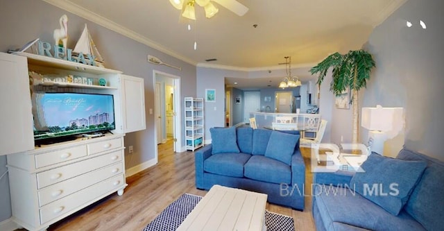 living room with ceiling fan with notable chandelier, light hardwood / wood-style flooring, and ornamental molding