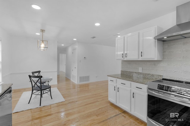 kitchen with stainless steel appliances, white cabinetry, stone counters, and wall chimney exhaust hood