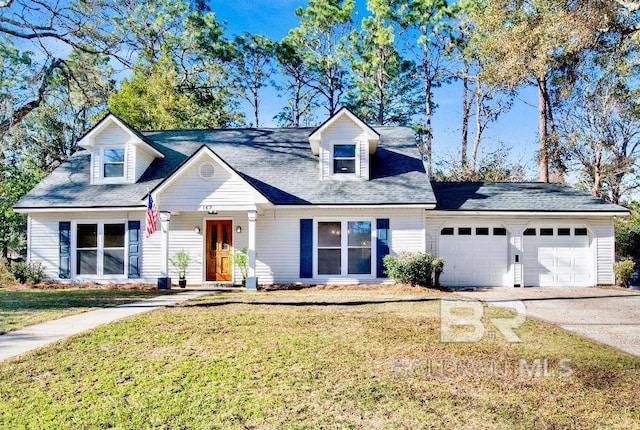 new england style home with an attached garage, concrete driveway, and a front yard