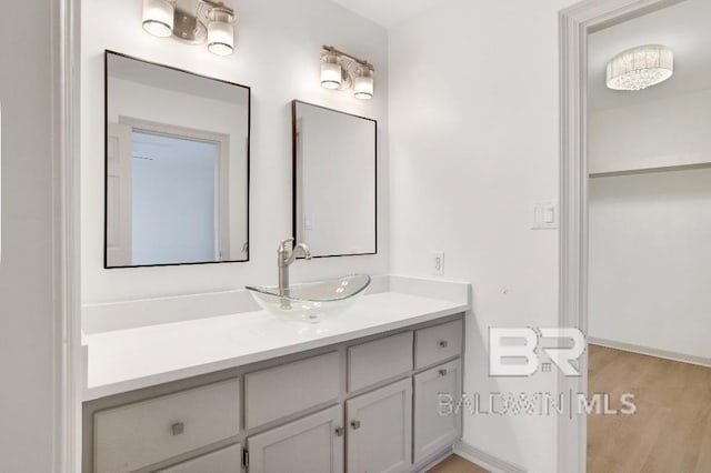 bathroom with wood finished floors, vanity, and baseboards