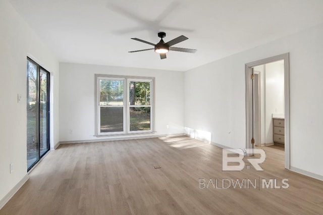 spare room with a ceiling fan, baseboards, and wood finished floors