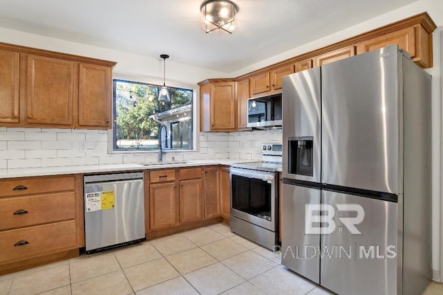 kitchen featuring appliances with stainless steel finishes, brown cabinetry, and a sink