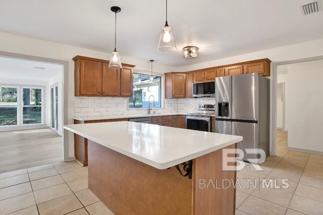 kitchen featuring light tile patterned floors, stainless steel appliances, visible vents, light countertops, and tasteful backsplash