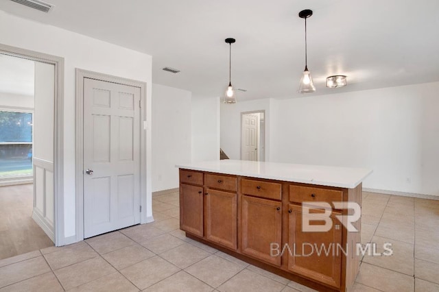 kitchen with visible vents, brown cabinetry, light countertops, and decorative light fixtures