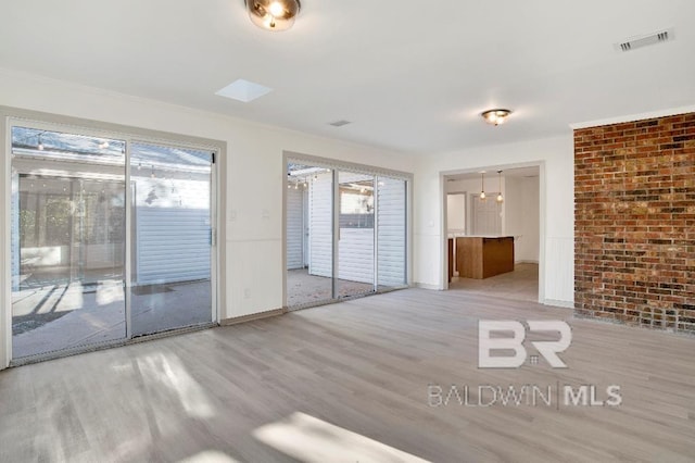 unfurnished room with visible vents and wood finished floors