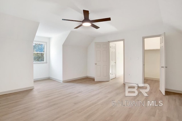 additional living space with a ceiling fan, vaulted ceiling, light wood-style flooring, and baseboards