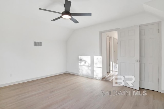 additional living space with vaulted ceiling, wood finished floors, visible vents, and baseboards