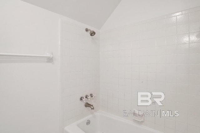 bathroom featuring lofted ceiling and bathing tub / shower combination