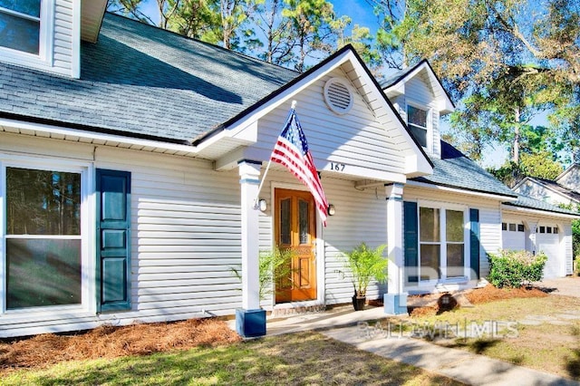 exterior space featuring a garage and a shingled roof