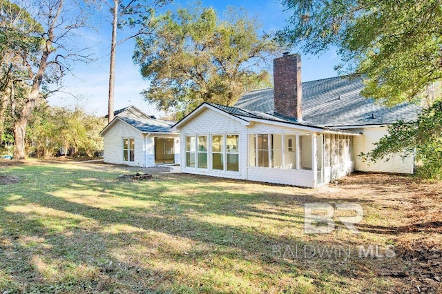 rear view of house with a lawn and a chimney