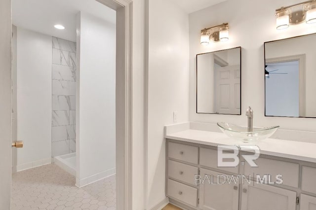 bathroom with a stall shower, vanity, baseboards, and recessed lighting