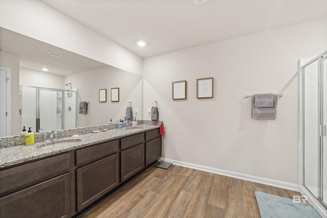 bathroom with hardwood / wood-style floors, vanity, and walk in shower