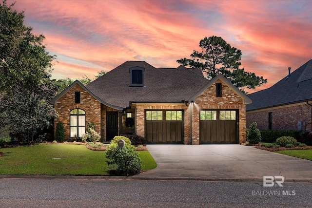 3609 Olde Park Rd, Gulf Shores, AL 36542 - view of front of house with a shingled roof, a yard, an attached garage, concrete driveway, and brick siding