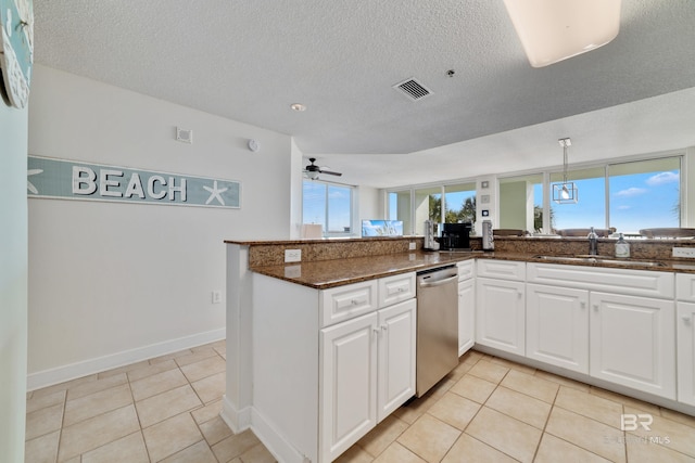 kitchen featuring visible vents, a sink, stainless steel dishwasher, white cabinets, and light tile patterned floors