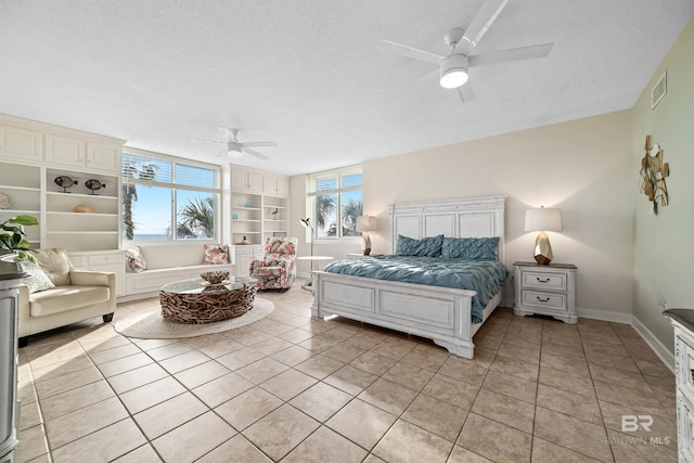 bedroom with light tile patterned flooring, baseboards, visible vents, and a textured ceiling