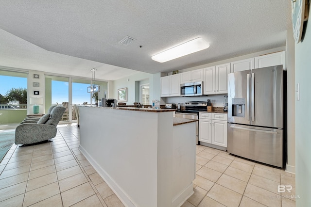 kitchen featuring light tile patterned floors, visible vents, appliances with stainless steel finishes, and white cabinets