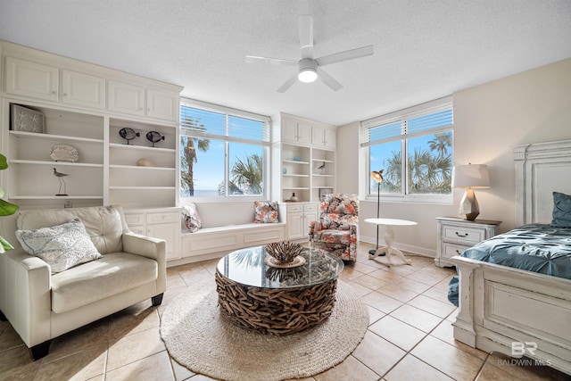 bedroom with light tile patterned flooring, multiple windows, a textured ceiling, and a ceiling fan