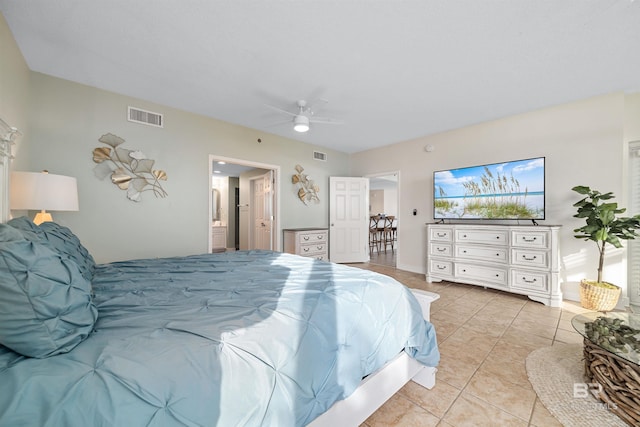 bedroom featuring ensuite bath, light tile patterned flooring, a ceiling fan, and visible vents