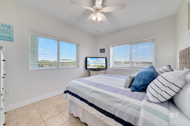 bedroom featuring light tile patterned floors, a ceiling fan, and baseboards