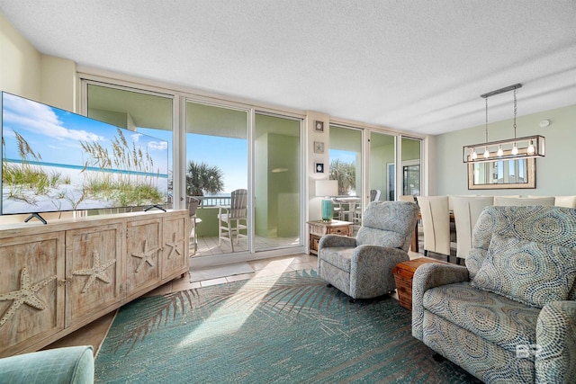 interior space with floor to ceiling windows, rail lighting, a textured ceiling, tile patterned floors, and a notable chandelier