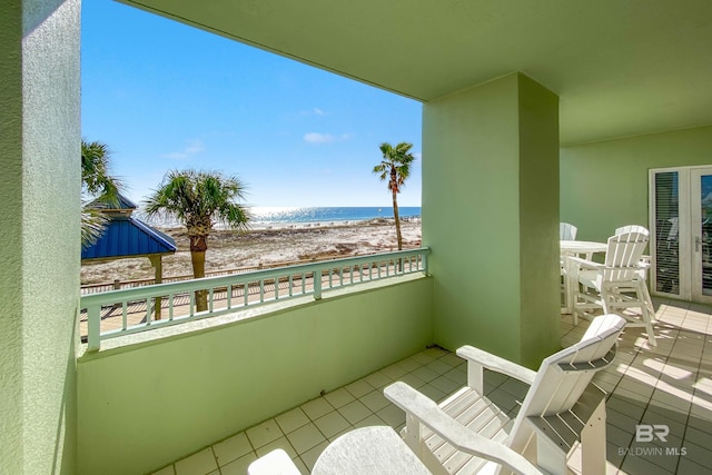 balcony featuring a water view and a beach view