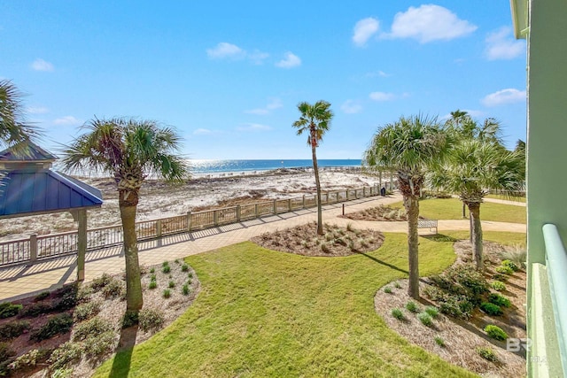 view of yard featuring a view of the beach, fence, and a water view