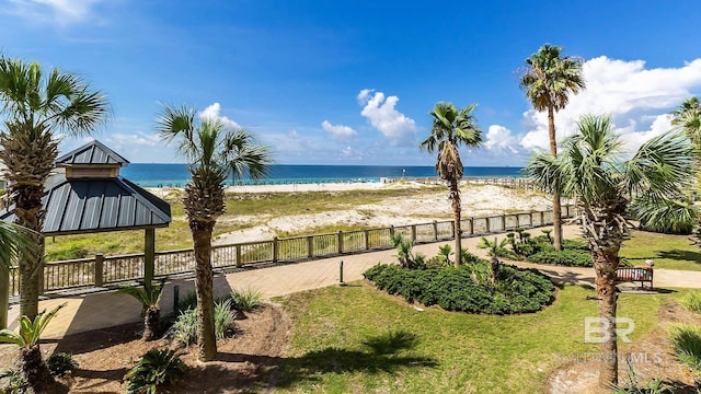 view of water feature featuring a gazebo, fence, and a view of the beach