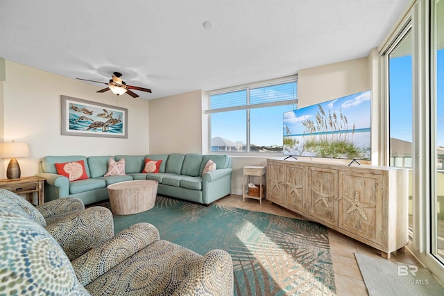 living room with light tile patterned floors, a textured ceiling, and ceiling fan