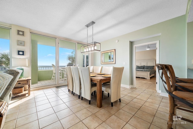 dining space with a textured ceiling, light tile patterned floors, and expansive windows