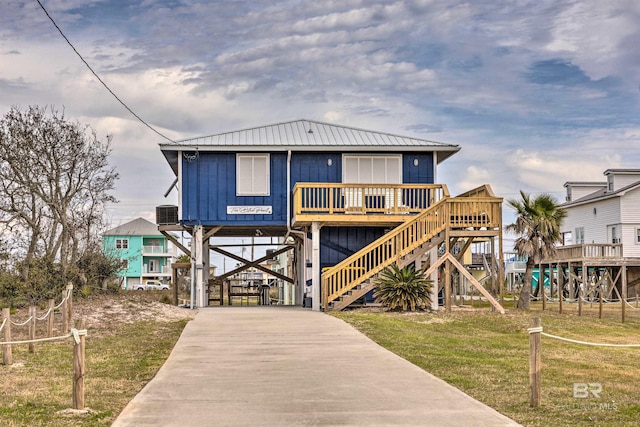 coastal inspired home with a carport and a front lawn