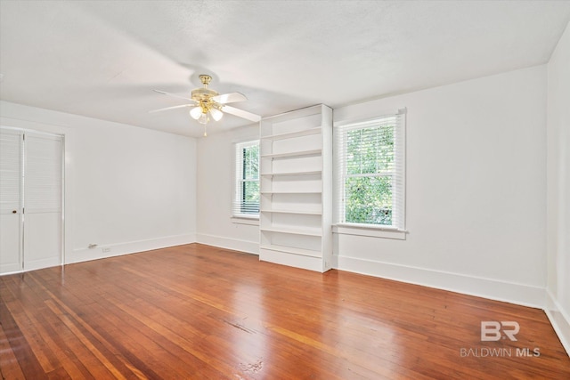 empty room with wood-type flooring and ceiling fan