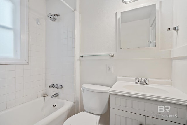 full bathroom featuring vanity, tiled shower / bath, and toilet