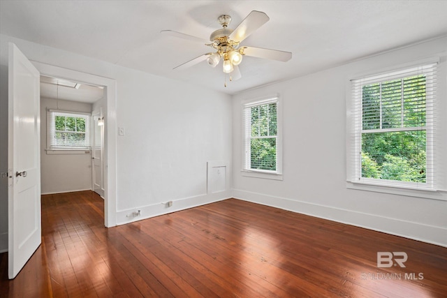 unfurnished room featuring a healthy amount of sunlight, dark wood-type flooring, and ceiling fan