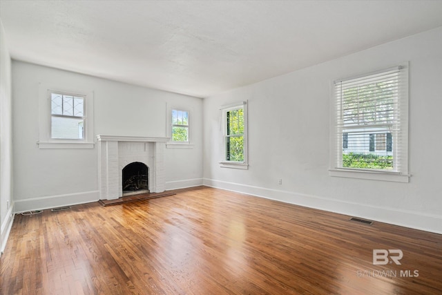 unfurnished living room with hardwood / wood-style flooring and a fireplace